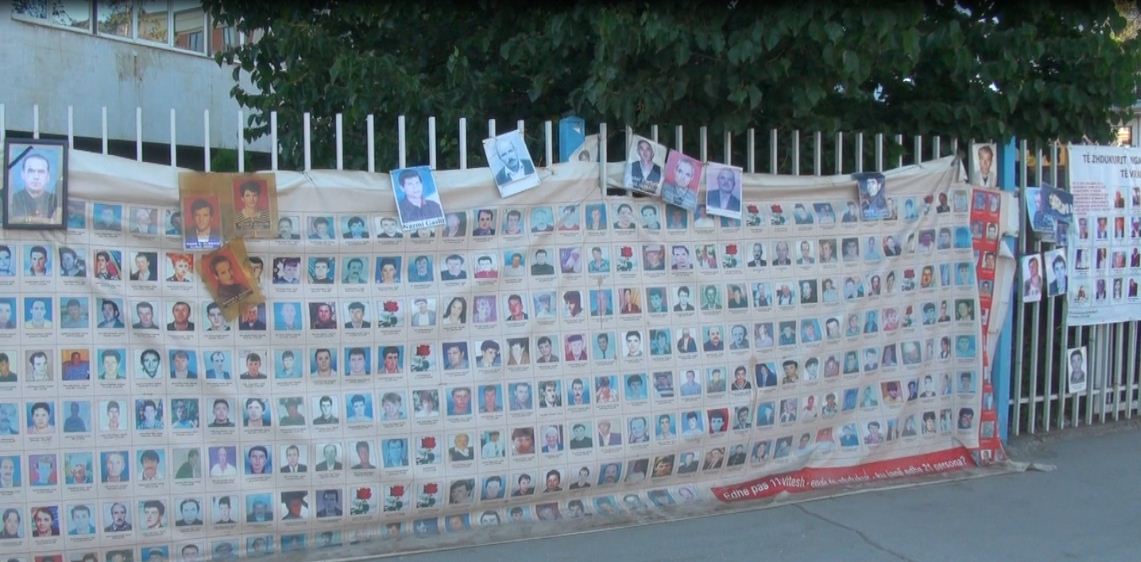 Per karą dingusių albanų nuotraukos ant Kosovo vyriausybės komplekso sienos.